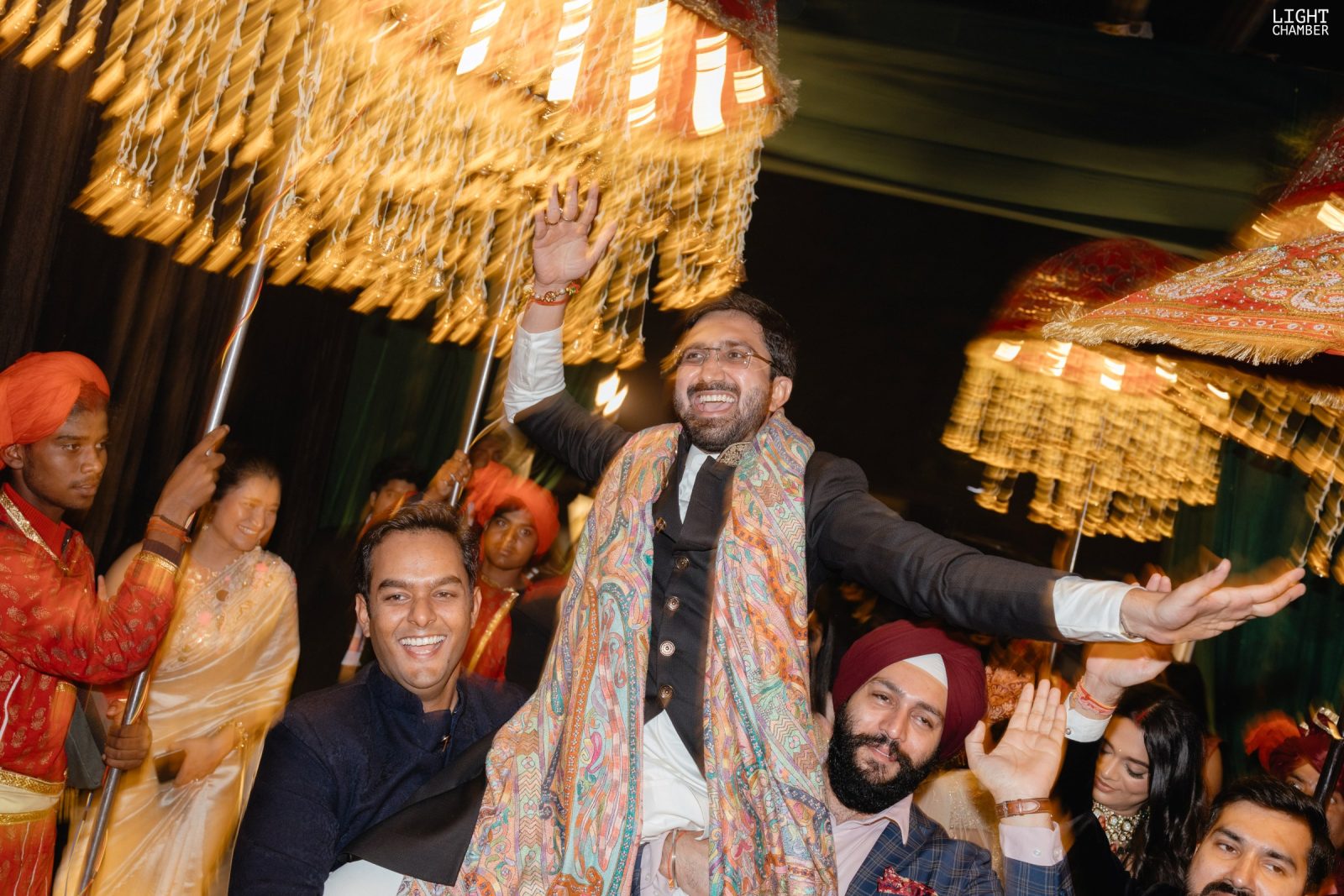 Guests mid-celebration, colour and confetti in the air