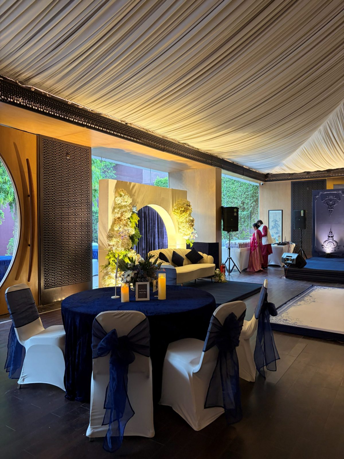 Navy velvet tablescape with gold candlelight and a tall floral centrepiece